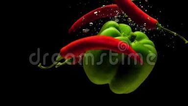 红辣椒和绿皮红辣椒在黑色的背景下<strong>落入</strong>水中